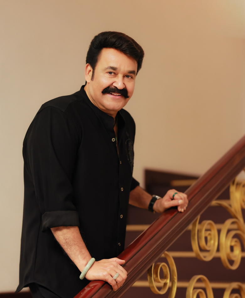 Mohanlal smiling beside a staircase